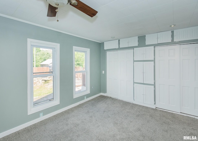 unfurnished bedroom with crown molding, light colored carpet, and ceiling fan