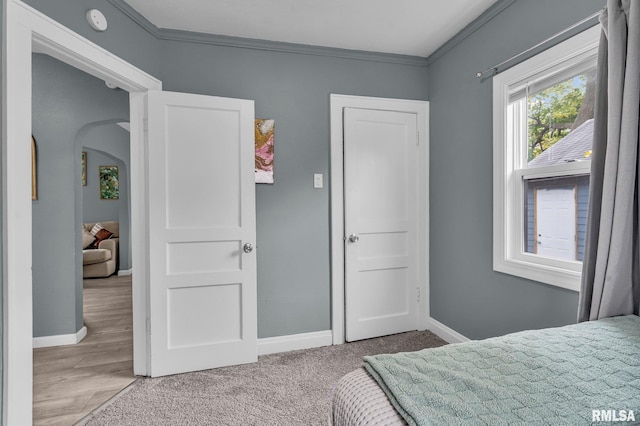 bedroom with crown molding and light wood-type flooring