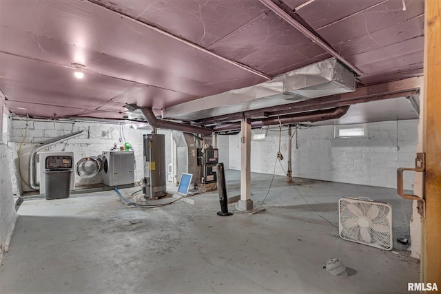 basement featuring heating unit, washer and clothes dryer, and water heater