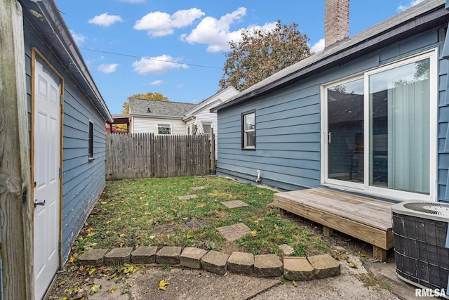 view of yard with central air condition unit and a deck