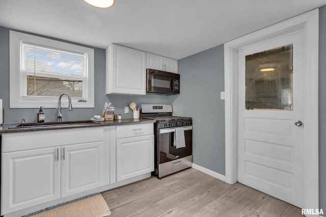 kitchen featuring white cabinetry, stainless steel gas stove, sink, and light wood-type flooring