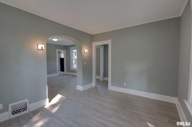 2312 W 1st St, Davenport, IA 52802 - unfurnished room featuring arched walkways, wood finished floors, and crown molding
