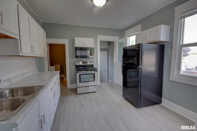 kitchen featuring decorative backsplash, white cabinetry, light wood-type flooring, black appliances, and light stone counters