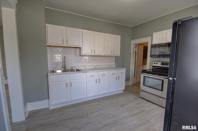 kitchen with backsplash, sink, black appliances, light wood-type flooring, and white cabinets