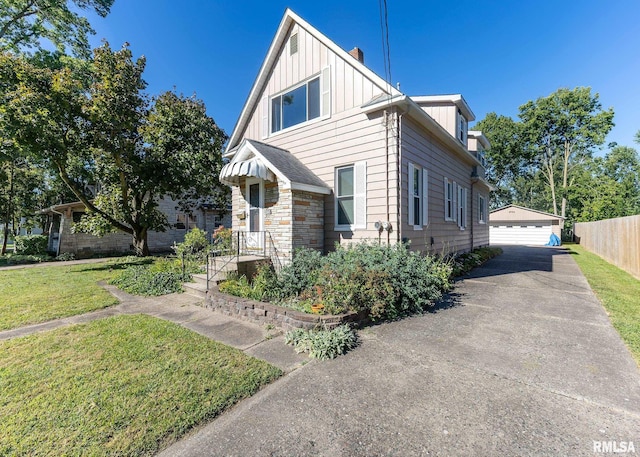 view of front of house with a garage, an outdoor structure, and a front lawn