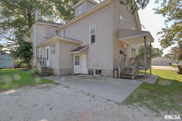 back of house with a yard, an outbuilding, and a garage