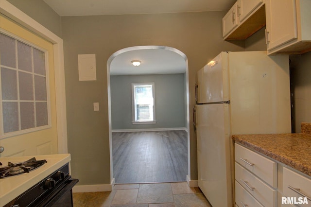 kitchen featuring white appliances, white cabinetry, and light wood-type flooring