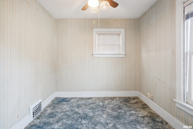 carpeted spare room featuring ceiling fan