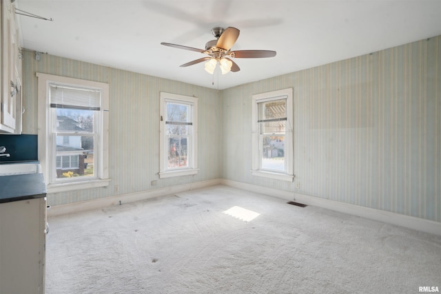 carpeted spare room with ceiling fan and sink