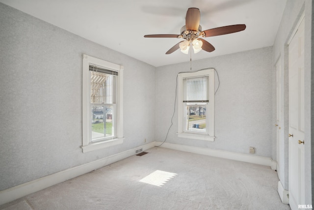 spare room featuring ceiling fan and light colored carpet