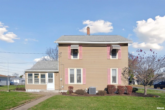 view of front facade with a front yard and central AC unit