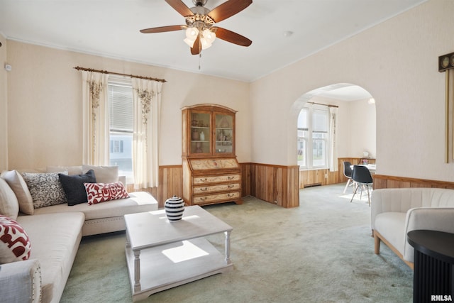 living room featuring plenty of natural light, ceiling fan, carpet floors, and wooden walls