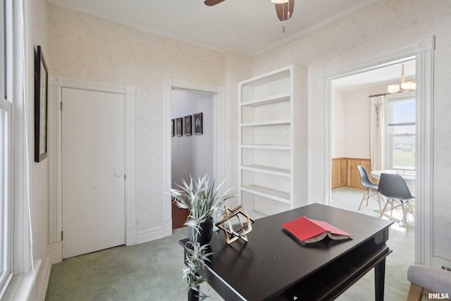 carpeted office with ceiling fan with notable chandelier and crown molding