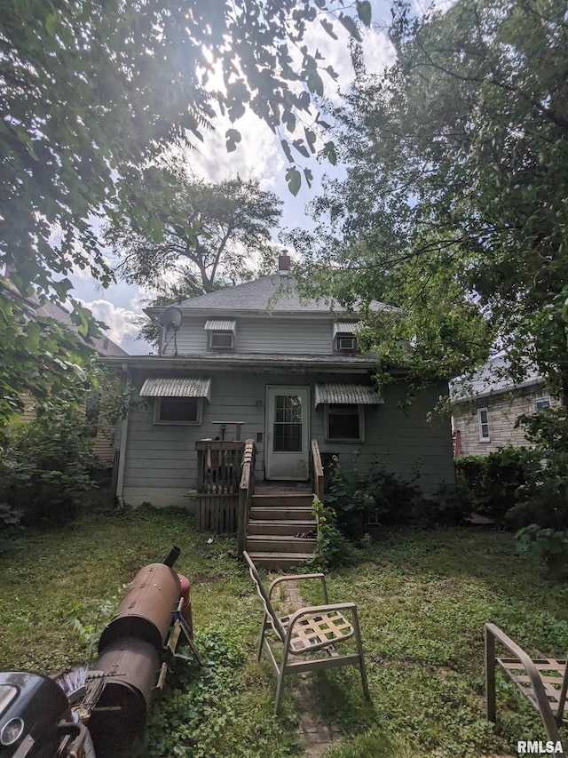 rear view of property featuring a yard