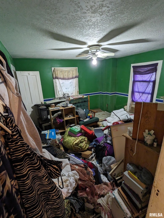 miscellaneous room featuring a textured ceiling and ceiling fan