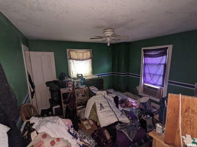 bedroom with ceiling fan, cooling unit, and a textured ceiling