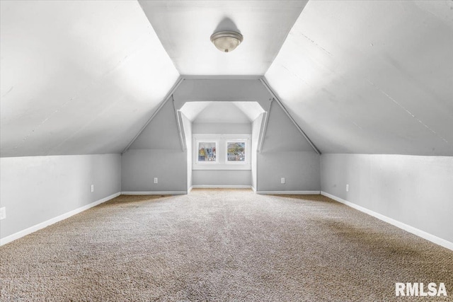 bonus room with vaulted ceiling and carpet floors