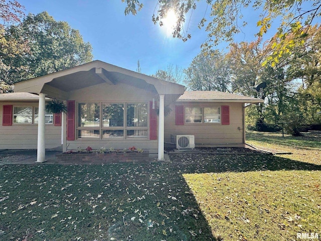 view of front facade featuring a front yard and ac unit