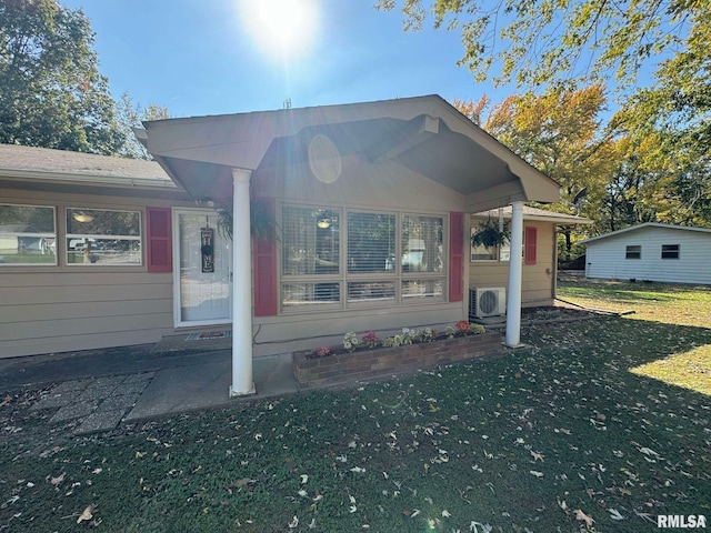 view of front of house featuring ac unit and a front lawn