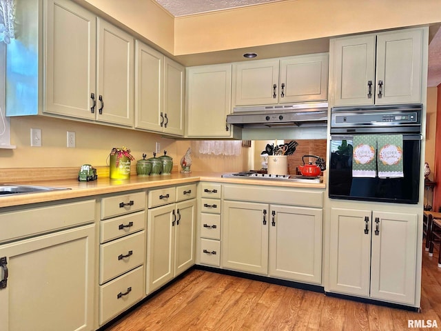 kitchen with sink, stainless steel gas cooktop, light wood-type flooring, and oven