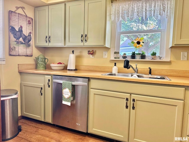 kitchen with stainless steel dishwasher, sink, light hardwood / wood-style flooring, and cream cabinets