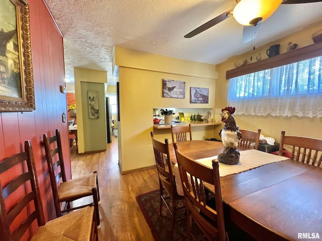 dining space featuring ceiling fan, a textured ceiling, and hardwood / wood-style floors