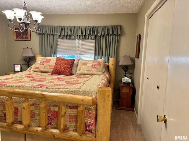 bedroom with a textured ceiling, a notable chandelier, carpet flooring, and a closet