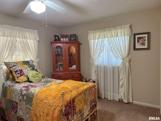 carpeted bedroom featuring a textured ceiling and ceiling fan