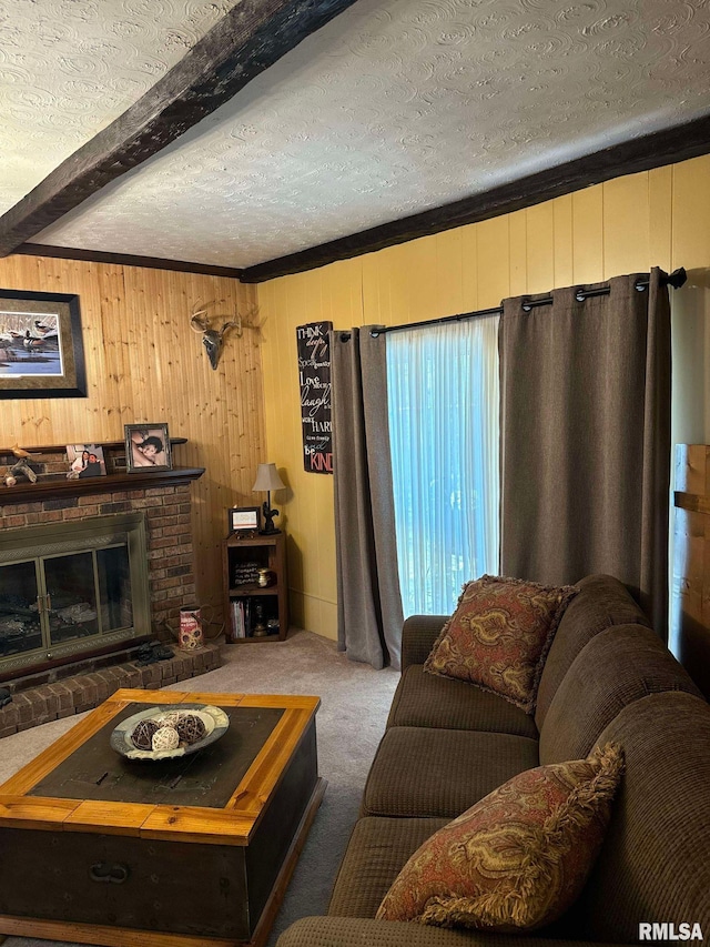 carpeted living room with beamed ceiling, wooden walls, crown molding, a textured ceiling, and a fireplace