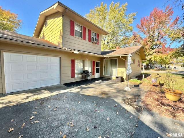 front of property featuring cooling unit and a garage