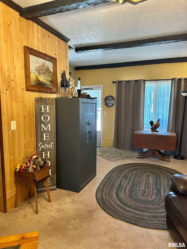 sitting room featuring light carpet and beam ceiling