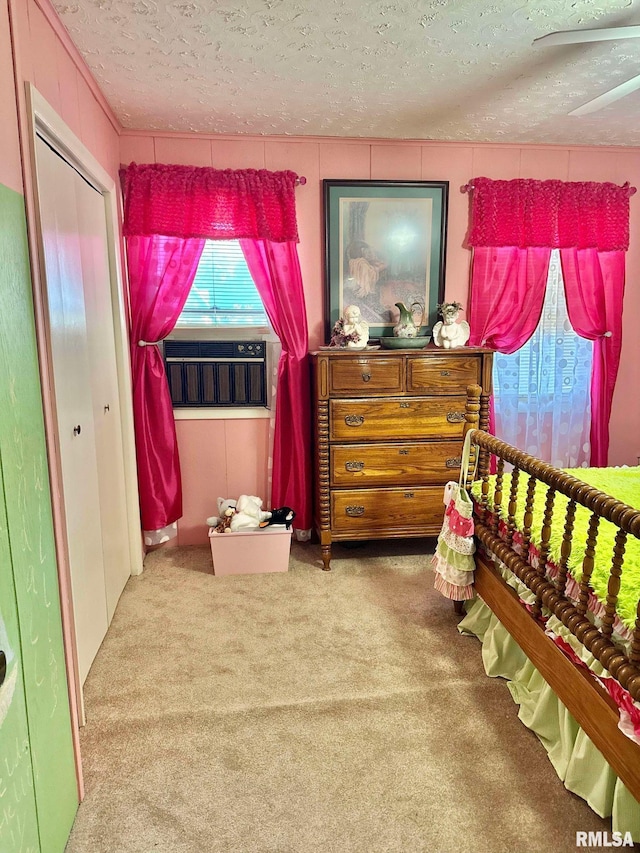 bedroom with a closet, ceiling fan, a textured ceiling, and carpet floors