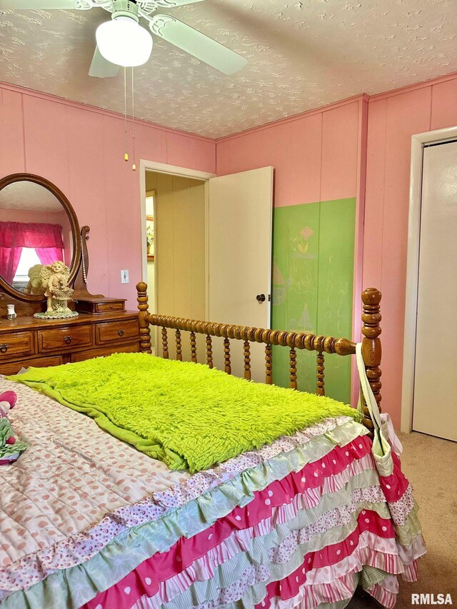 bedroom with a textured ceiling, carpet, and ceiling fan