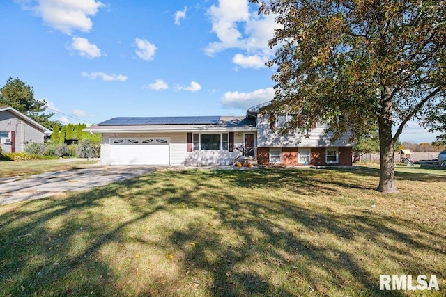 split level home featuring solar panels, a garage, and a front lawn