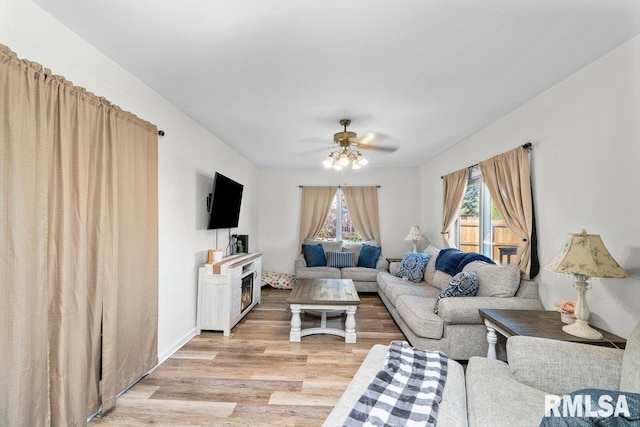 living room featuring light wood-type flooring and ceiling fan