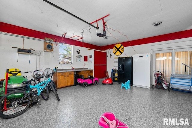 garage featuring a garage door opener and black fridge