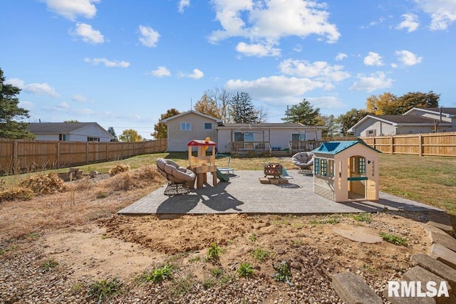 rear view of property with a yard, an outdoor fire pit, and a patio area