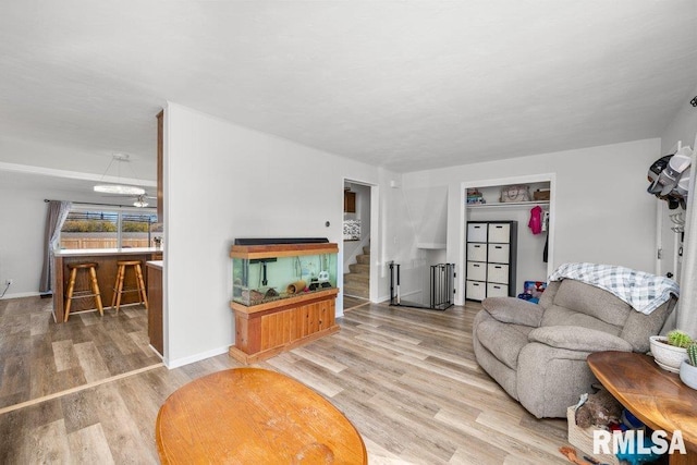 living room with a notable chandelier, wood-type flooring, and radiator heating unit