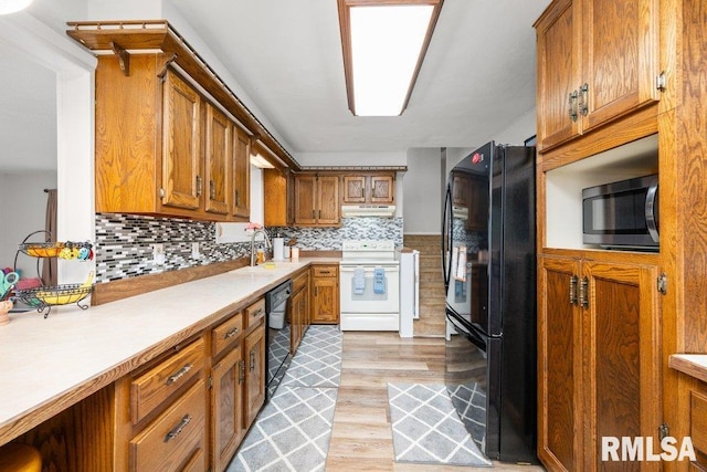 kitchen with light hardwood / wood-style flooring, tasteful backsplash, black appliances, and sink