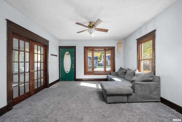 carpeted living room with french doors, a textured ceiling, and ceiling fan