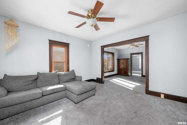 unfurnished living room with a textured ceiling, carpet floors, and ceiling fan