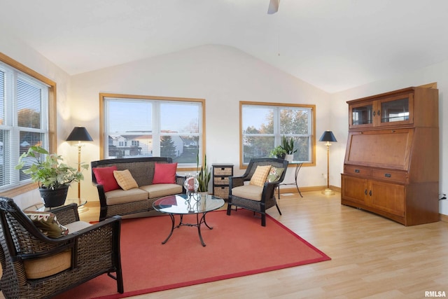 living room featuring lofted ceiling and light hardwood / wood-style floors