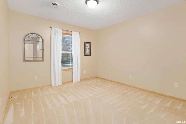 empty room with a textured ceiling and carpet floors