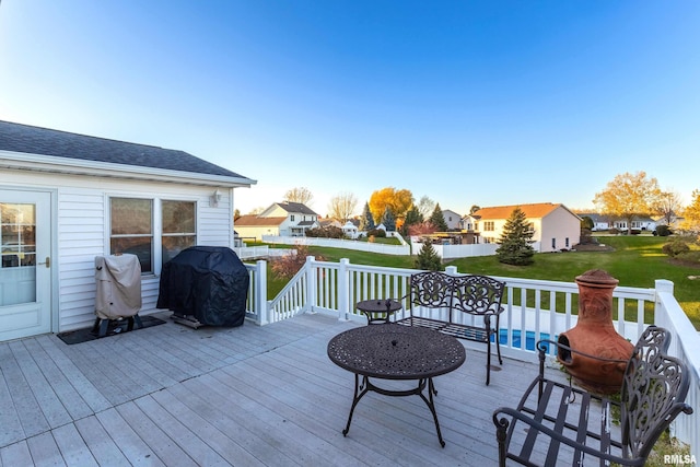 deck with a lawn and grilling area