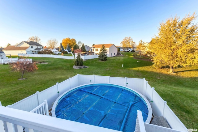 view of pool with a lawn