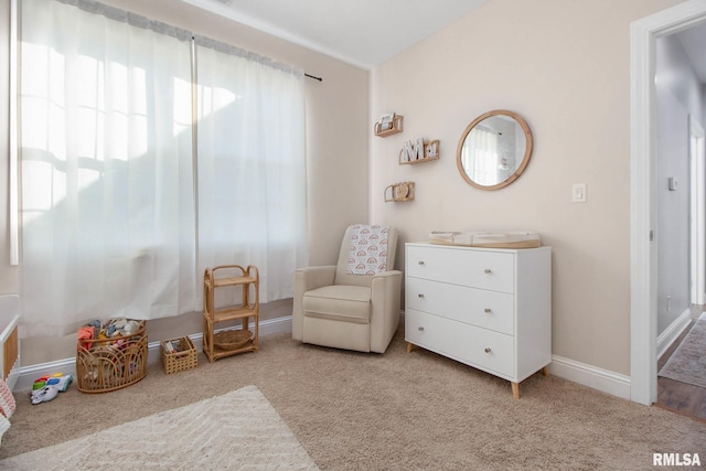 living area with a healthy amount of sunlight and light colored carpet