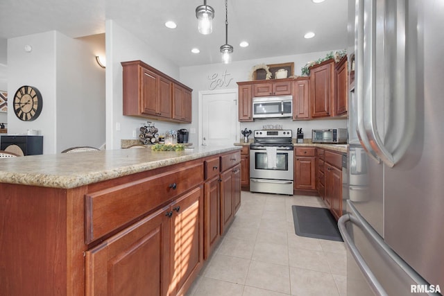 kitchen with a kitchen island, stainless steel appliances, hanging light fixtures, and light tile patterned floors