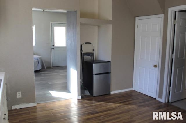 interior space with stainless steel fridge and dark wood-type flooring