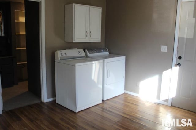 laundry room with washer and dryer, cabinets, and dark wood-type flooring