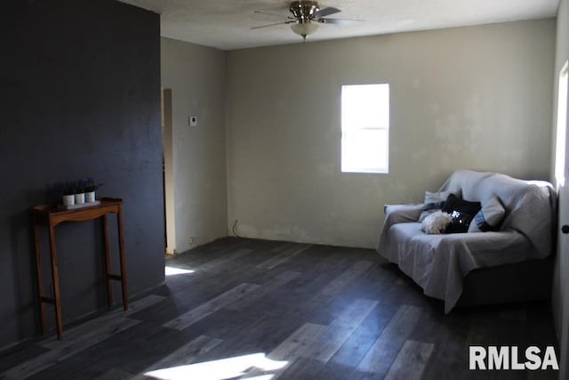 living area with ceiling fan and dark hardwood / wood-style flooring